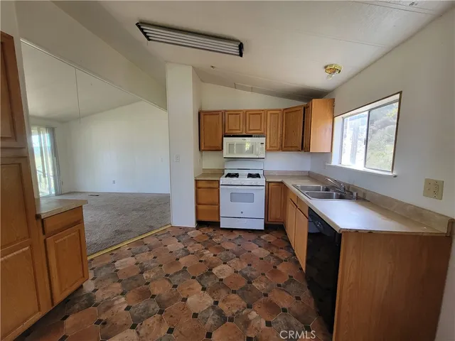 a view of a livingroom with wooden floor and a bathroom