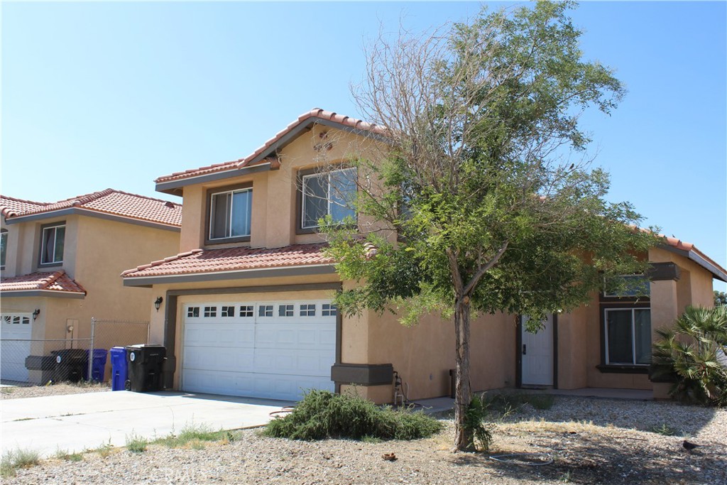 15705 Tern Road Victorville, CA 92394 - Photo 2 of 4 a front view of a house with a yard and garage