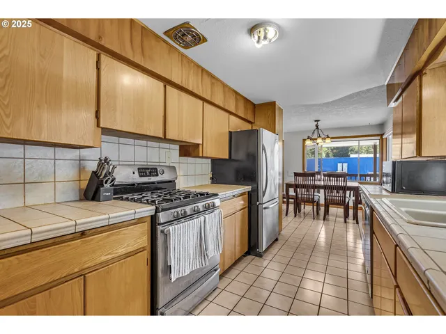 a kitchen with a stove a sink dishwasher and a refrigerator