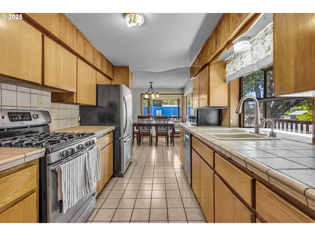 a kitchen with granite countertop a stove a sink dishwasher and cabinets with wooden floor