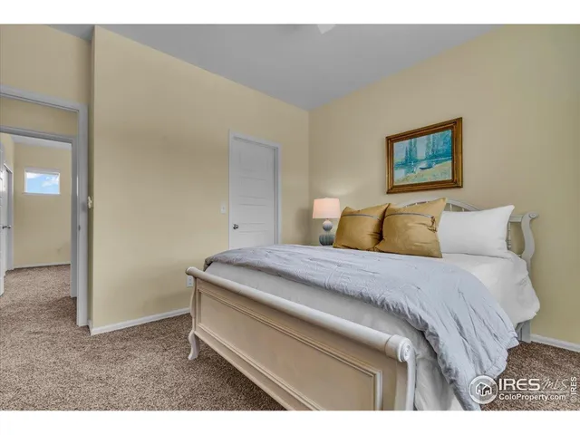 a bedroom with a bed and a painting on the wall