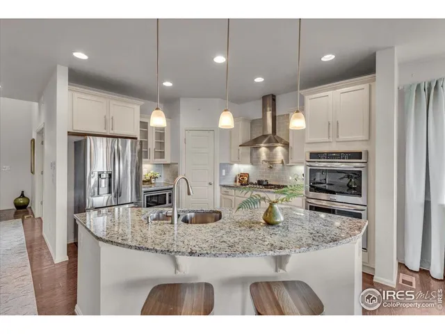 a kitchen with stainless steel appliances granite countertop a sink refrigerator and cabinets