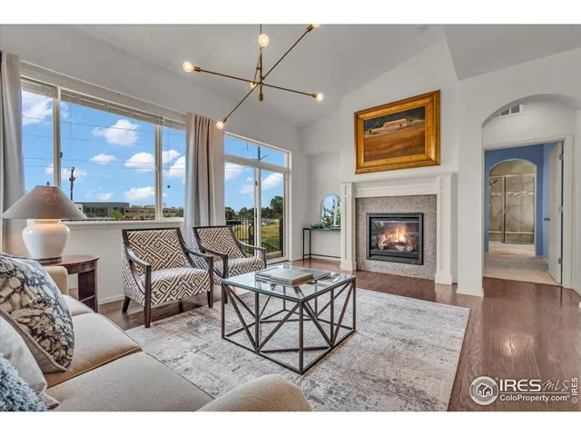 a living room with furniture a large window and a fireplace