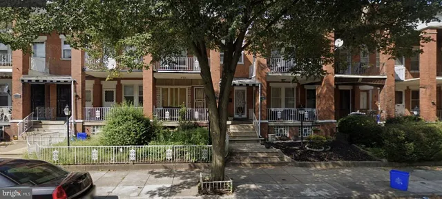 a view of backyard with wheel chair potted plants and large tree