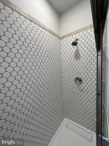 a view of an empty room with wooden floor and window