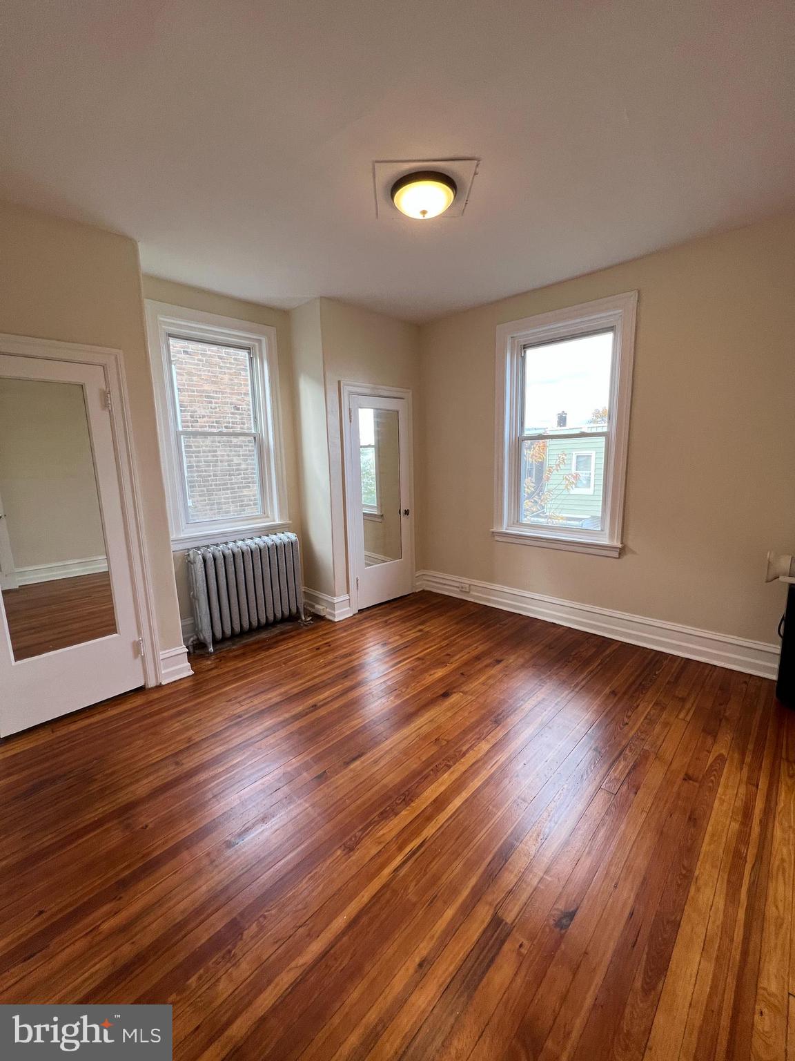 5931 Carpenter Street Philadelphia, PA 19143 - Photo 15 of 15 a view of an empty room with wooden floor and window