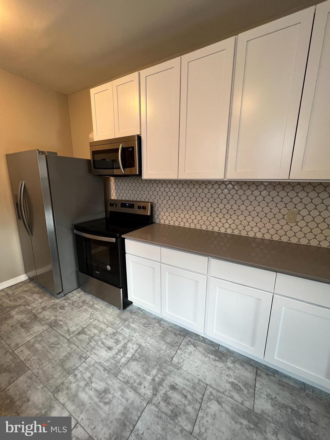 5931 Carpenter Street Philadelphia, PA 19143 - Photo 9 of 15 a kitchen with stainless steel appliances granite countertop a refrigerator sink and cabinets