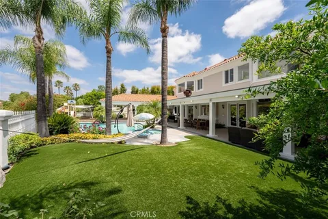 an aerial view of a swimming pool with a yard and outdoor seating