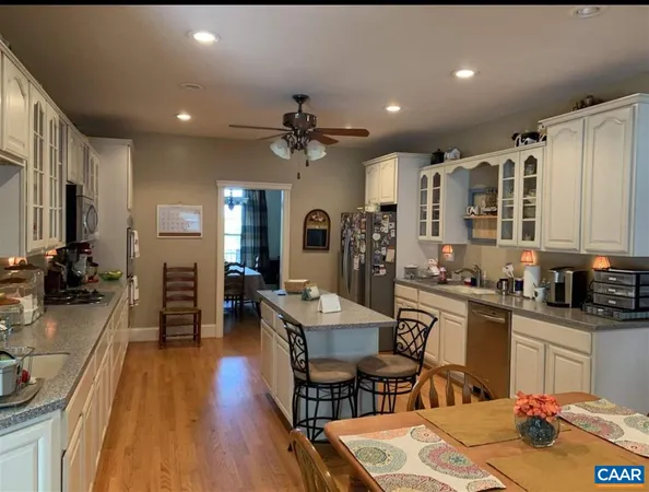a large kitchen with kitchen island a large counter space a sink a window and stainless steel appliances