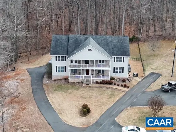an aerial view of a house with a big yard and large trees
