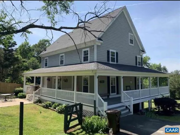 a view of a house with a big yard and a large tree