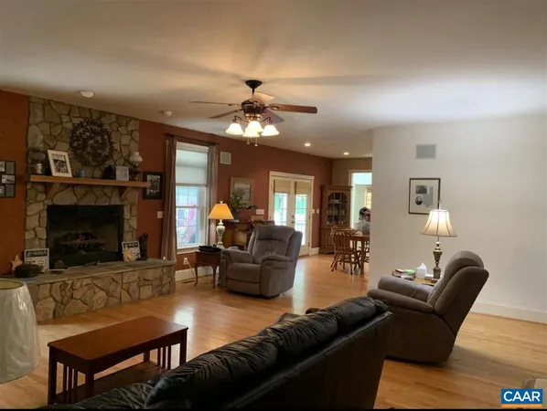 a kitchen with stainless steel appliances granite countertop a stove a sink dishwasher a dining table and chairs with wooden floor