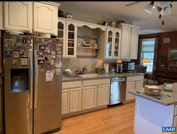 a kitchen with stainless steel appliances granite countertop sink stove refrigerator dining table and chairs