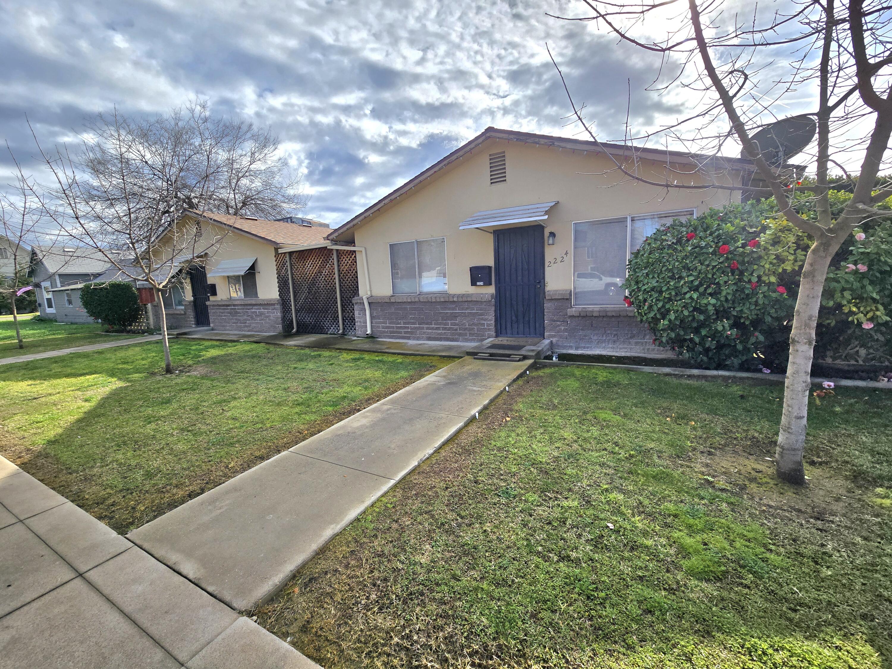 2222-2224 11th Street Reedley, CA 93654 - Photo 3 of 11 a front view of a house with a yard and garage