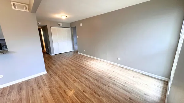 a view of an empty room and wooden floor