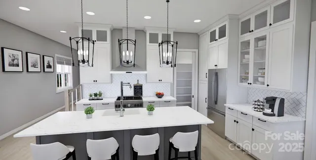 a kitchen with stainless steel appliances kitchen island granite countertop a dining table chairs and white cabinets