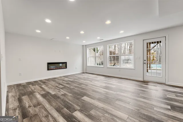 a view of empty room with wooden floor and fireplace
