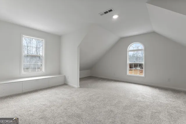 an empty room with a window and a bathroom