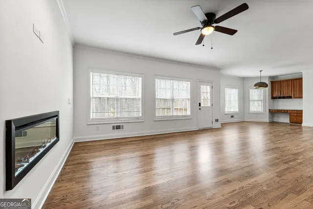 a view of staircase with kitchen island stainless steel appliances wooden floor and chandelier