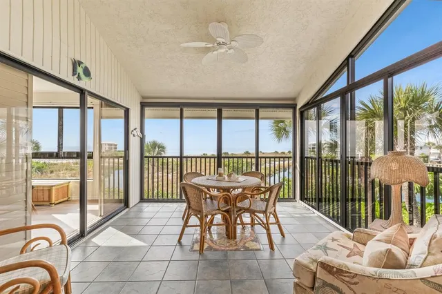 a dining room with furniture water view and a floor to ceiling window