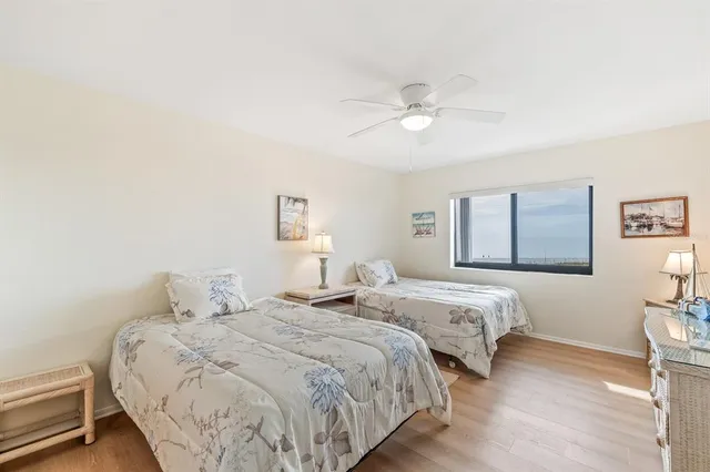 a bedroom with two beds and a ceiling fan