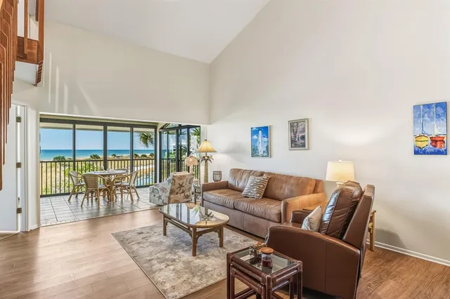 a living room with furniture floor to ceiling window and wooden floor