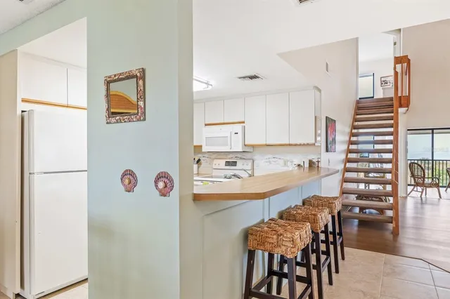 a kitchen with a refrigerator and chairs