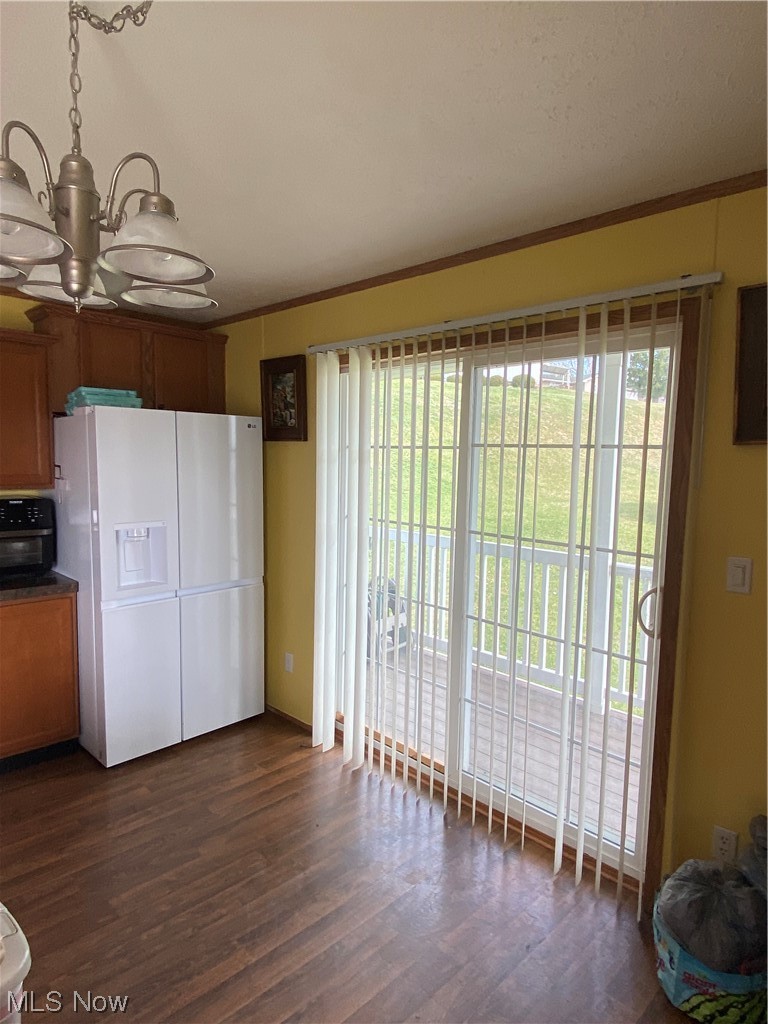 85 Rains Circle Zanesville, OH 43701 - Photo 7 of 15 Kitchen with refrigerator, a chandelier, dark hardwood / wood-style flooring, and ornamental molding. Nice sliding glass doors leading to covered deck