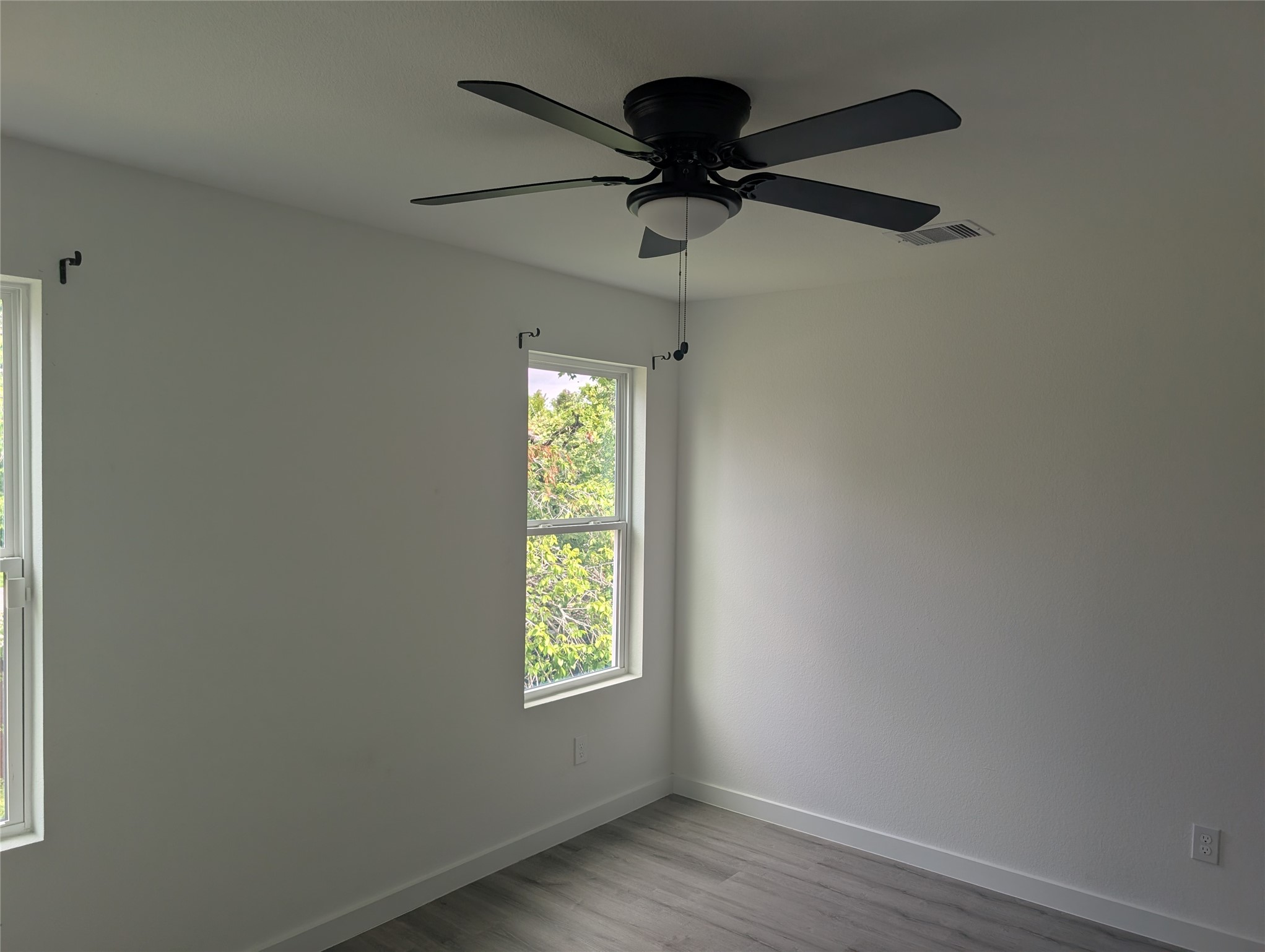 7813 Hirsch Road, Unit B Houston, TX 77016 - Photo 5 of 8 an empty room with a window and a fan