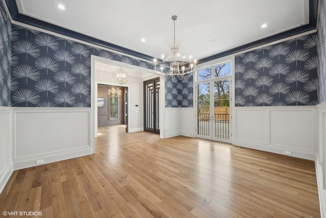 a view of a livingroom with wooden floor and chandelier