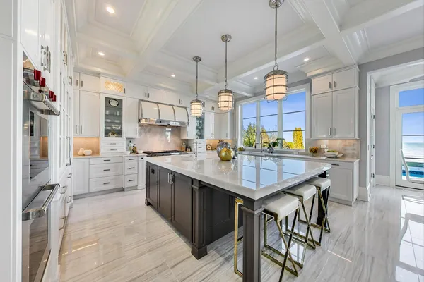 a kitchen with stainless steel appliances kitchen island granite countertop a table chairs and a refrigerator