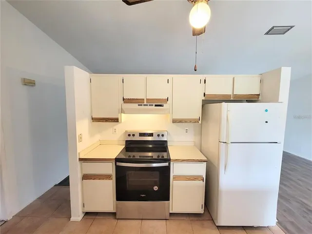 a kitchen with stainless steel appliances a sink and a wooden floor