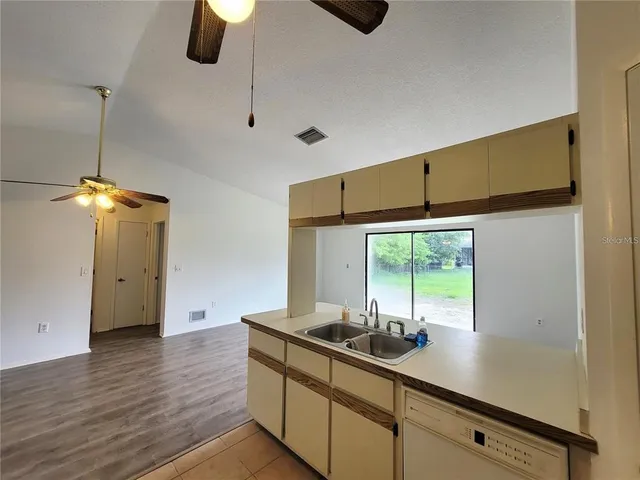 a kitchen with stainless steel appliances wooden floor and a refrigerator