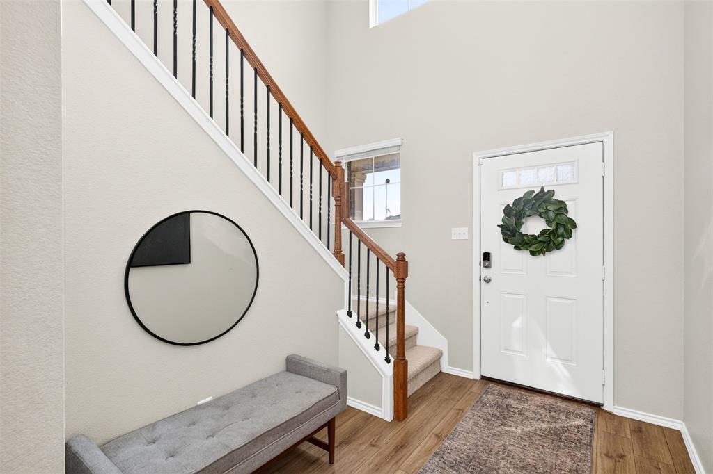 3105 Marston Road Lorena, TX 76655 - Photo 4 of 40 Entryway featuring wood-finish flooring, a white paneled door with decorative window inserts, and a staircase with wood handrails and black metal balusters