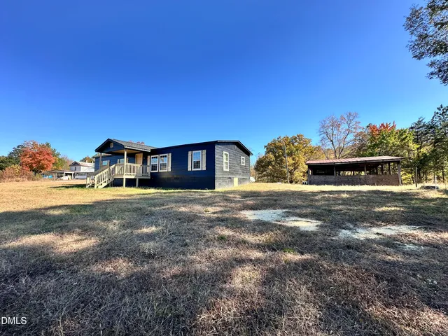 a front view of a house with large trees