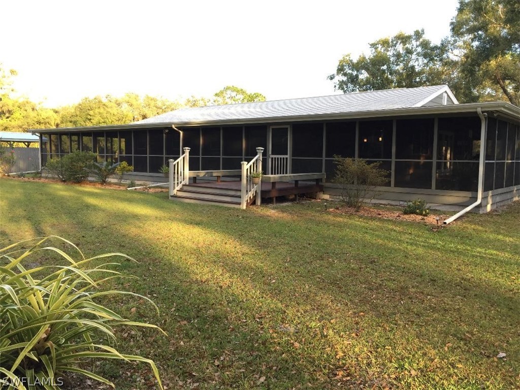 3031 Packinghouse Road Alva, FL 33920 - Photo 1 of 24 a front view of a house with a yard table and chairs