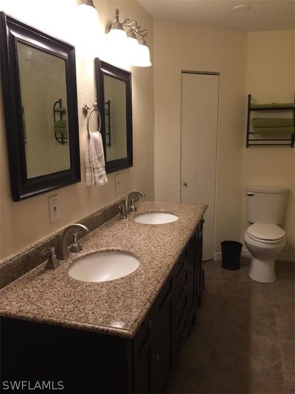3031 Packinghouse Road Alva, FL 33920 - Photo 16 of 24 a bathroom with a granite countertop sink a toilet and mirror