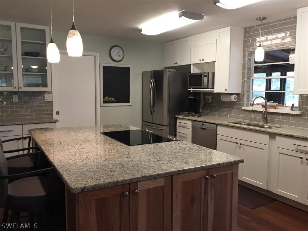 3031 Packinghouse Road Alva, FL 33920 - Photo 8 of 24 a kitchen with granite countertop stainless steel appliances a sink cabinets and wooden floor