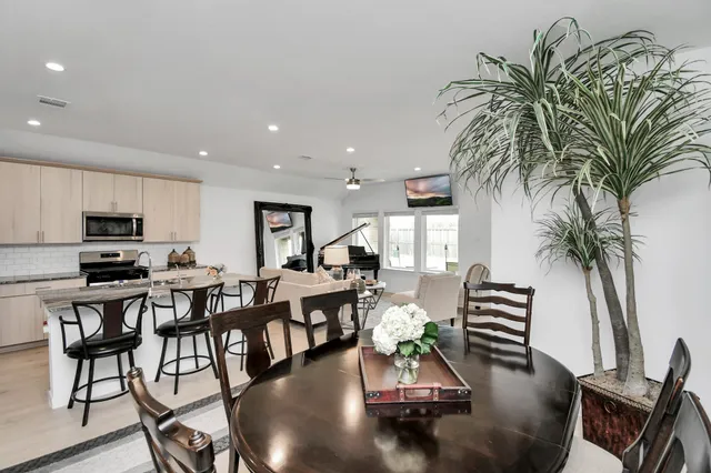 a living room with furniture kitchen view and a potted plant