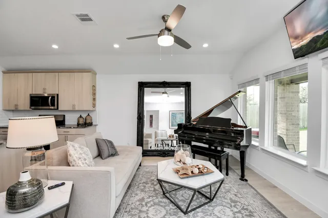 a living room with furniture a flat screen tv and a window