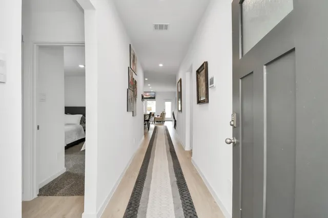 a view of a hallway with a white walls and stairs