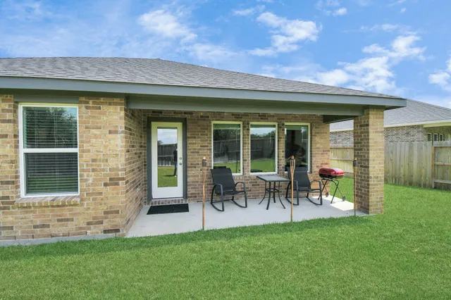a view of a house with a backyard and a patio