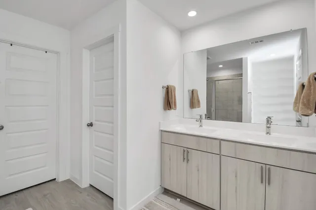 a bathroom with a double vanity sink and mirror