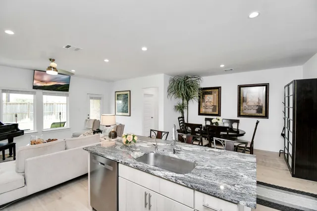 a living room with granite countertop furniture and a flat screen tv