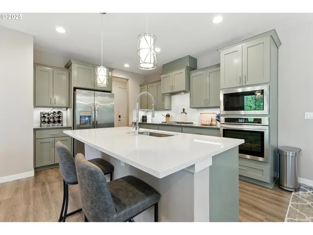 a kitchen with kitchen island granite countertop a sink cabinets and stainless steel appliances
