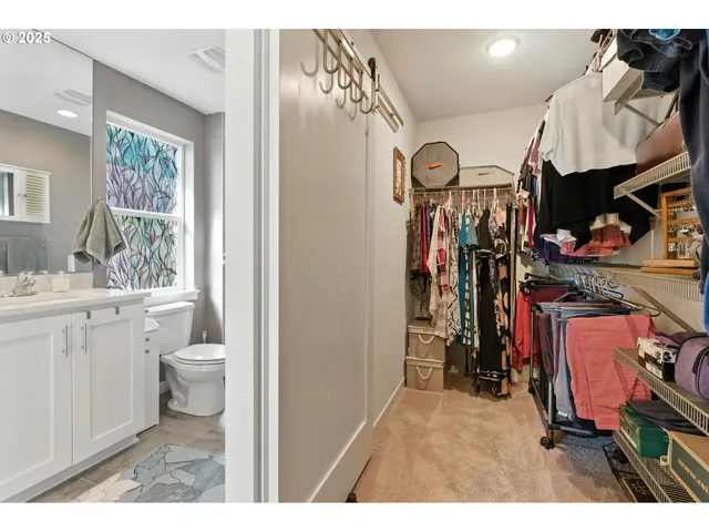 a view of a hallway with bathroom and a sink