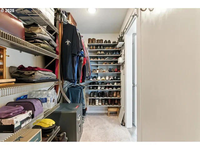 a view of walk in closet with clothes and shoes