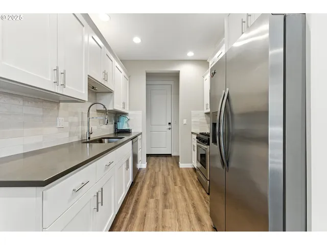 a kitchen with stainless steel appliances granite countertop a refrigerator and a sink