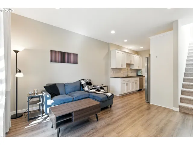 a living room with furniture and a wooden floor