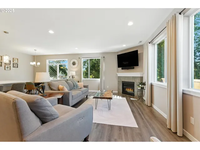 a living room with furniture a fireplace and a flat screen tv
